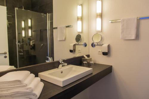 科赫姆科赫伊姆公寓式酒店的浴室配有盥洗盆、镜子和毛巾