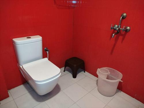 加尔各答Offbeat CCU Bunkers的红色的浴室设有卫生间和垃圾桶