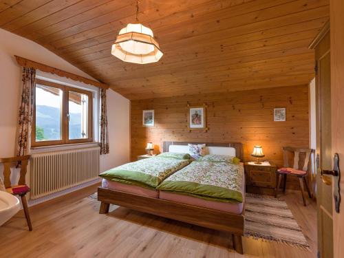 蒂罗尔州圣约翰Wolkenmooshof的一间卧室设有一张床和木墙