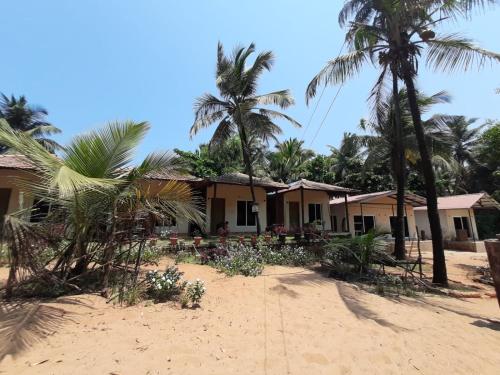 戈卡尔纳Trippr Gokarna - Beach Hostel的棕榈树海滩上的房子