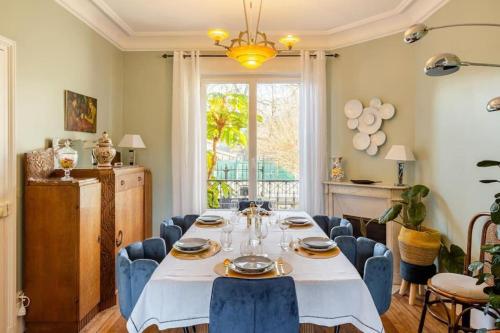 德拉韦伊luxury Villa Marie Emeraude Paris Orly Jacuzzi的一间带桌子和蓝色椅子的用餐室