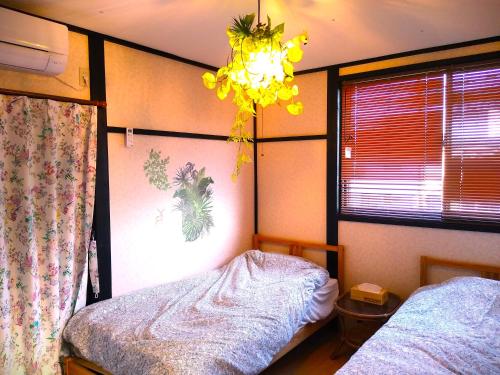 千仓町シーカレント　ゆな　CHIKURA的一间卧室配有一张床和一个吊灯