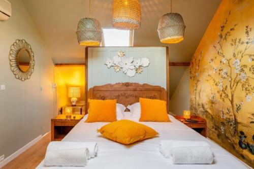 德拉韦伊luxury Villa Marie Emeraude Paris Orly Jacuzzi的一间卧室配有一张带黄色枕头的大床