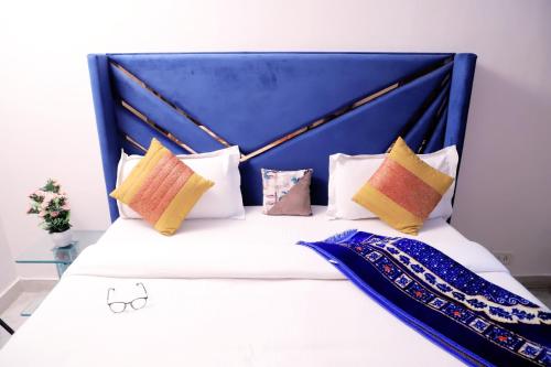 新德里Fortune Home Service Apartment 1bhk, D-198,UGF的一张带蓝色床头板和枕头的床