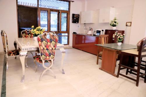 新德里Fortune Home Service Apartment 1bhk, D-198,UGF的厨房以及带桌椅的用餐室。