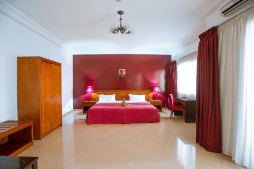 达喀尔拉斐尔特酒店的一间卧室设有一张红色墙壁的大床
