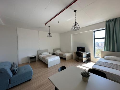 地拉那ApartHotel Folé的一间带两张床和一张沙发的客厅
