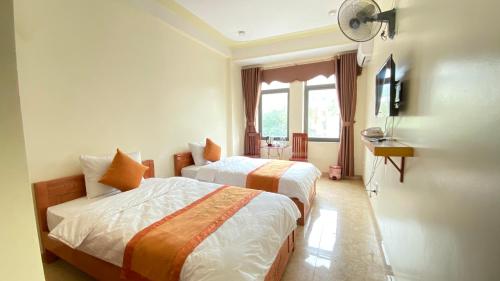 河江Sun Hà Giang Hotel的酒店客房设有两张床和窗户。