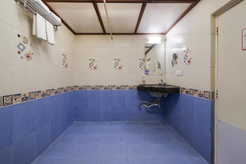 浦那7 Apple Hotel Pimpri Pune的浴室铺有蓝色和白色瓷砖,配有水槽