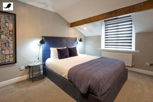 布莱克浦Blackbird Luxury Apartments Room 4的一间卧室配有一张带蓝色床头板的床和窗户