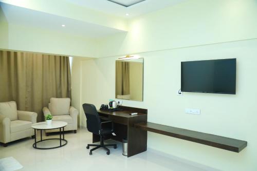 孟买Country Inn & Suites By Turtle的客房设有书桌和墙上的电视