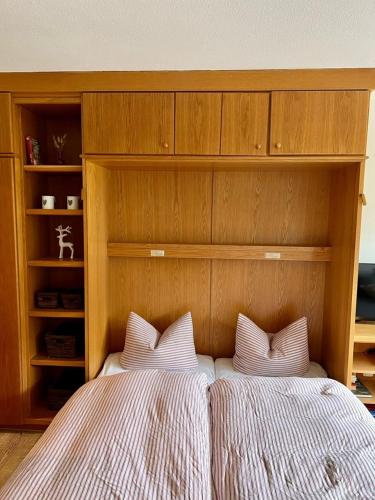 巴特欣德朗Fewo im Sonnenpark的卧室内的一张带两个白色枕头的床