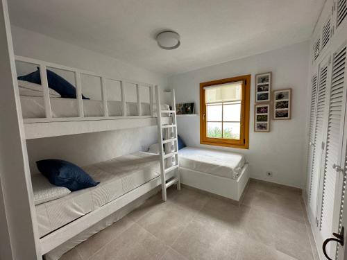 桑帕克ALDEAMAR F1 by SOM Menorca的一间卧室设有两张双层床和一扇窗户。