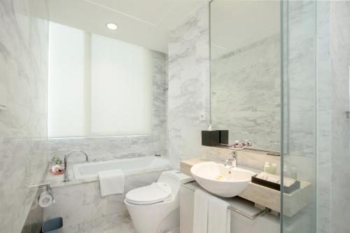 雅加达雅加达苏迪曼辉盛庭国际公寓的浴室配有卫生间、盥洗盆和浴缸。