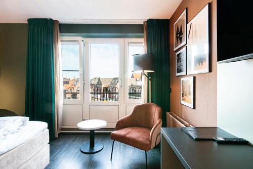 福伦丹Hotel Old Dutch的客房设有床、椅子和窗户。