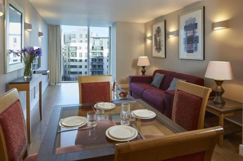 伦敦Marlin Apartments London Bridge - Empire Square的客厅配有桌子和沙发