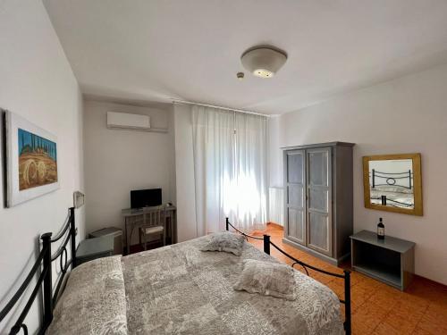 蒙特普齐亚诺马文酒店的一间卧室配有一张床、一台电视和一个窗口