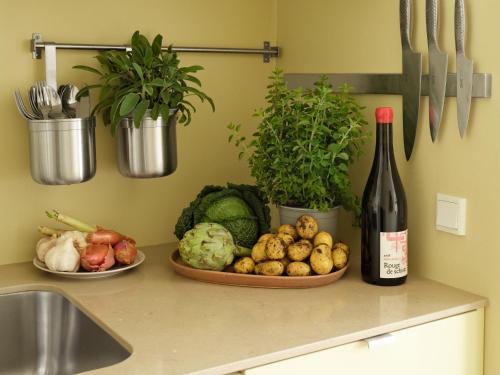 哥本哈根Apēron Apartment Hotel的柜台上放一瓶葡萄酒和一盘蔬菜