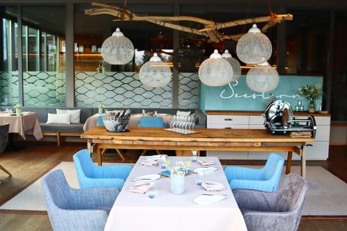 乌尔姆希尔LAGO餐厅&酒店的一间带桌子和蓝色椅子的用餐室