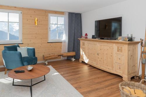 StaldenriedFerienwohnung的客厅配有电视、沙发和桌子
