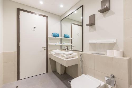 迪拜Revelton Apartment One Residence的一间带水槽、卫生间和镜子的浴室