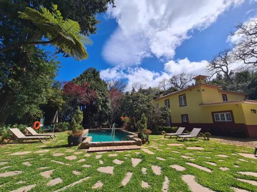 卡马查Quinta da Moscadinha的一个带游泳池和房子的后院