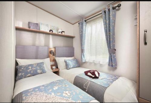 佩恩顿Hoburne Devon Bay stunning 3 bed luxury lodge的一间小卧室,配有两张床和窗户