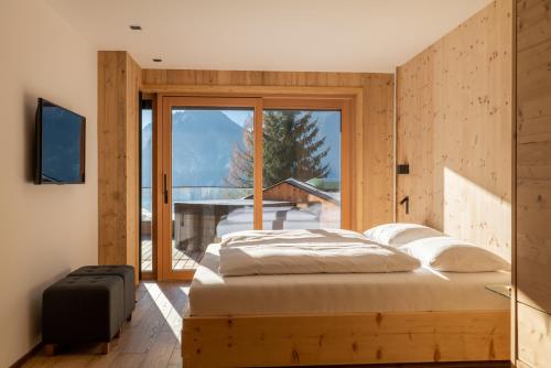 奇勒谷地拉姆绍Chalet Residenz Zillertal Mühlermoos的一间卧室设有一张床和一个大窗户