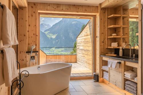 奇勒谷地拉姆绍Chalet Residenz Zillertal Mühlermoos的带浴缸的浴室和大窗户