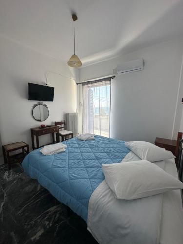 阿马林索斯To Kyma的一间卧室配有一张带蓝色毯子的大床