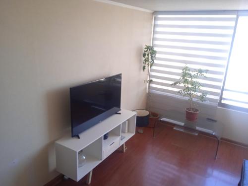 圣地亚哥圣地亚哥中心公寓的客厅配有白色橱柜上的平面电视