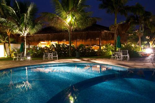 安格拉杜斯雷斯Hotel do Bosque ECO Resort的游泳池,晚上配有椅子和棕榈树