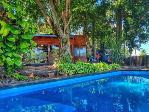 伊瓜苏港La Casa Del Lago URUGUA-Í的一座带游泳池和树木的房子