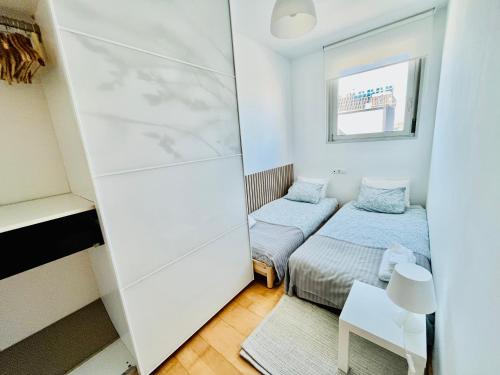 巴塞罗那Beach & Culture Barcelona Port Forum Penthouse Apartment的小房间设有两张床和镜子