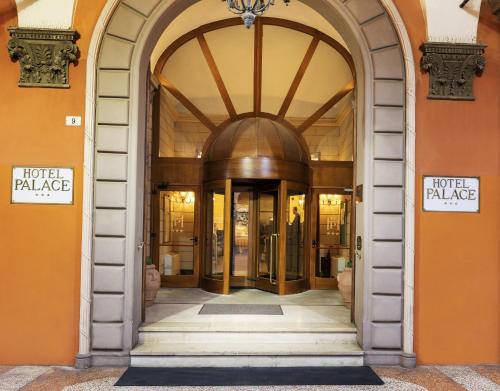 博洛尼亚Hotel Palace Bologna Centro的通往酒店宫殿建筑的拱形门道