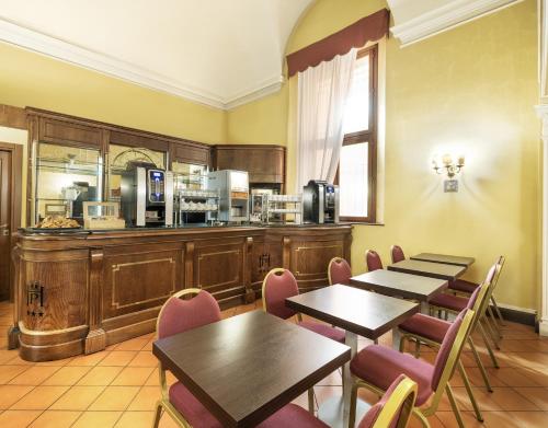 博洛尼亚Hotel Palace Bologna Centro的一间带桌椅的餐厅和一间厨房