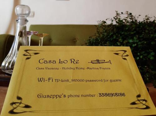 马丁纳弗兰卡Casa Lo Re的桌子上的标志和一瓶葡萄酒