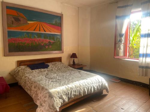 亚的斯亚贝巴Wim's Holland House的卧室配有一张床,墙上挂有绘画作品