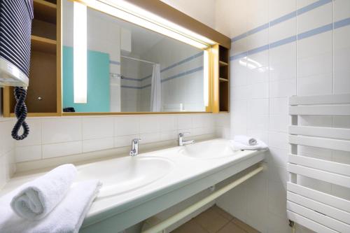 圣马梅特Village Club Les Balcons des Pyrénées的白色的浴室设有水槽和镜子