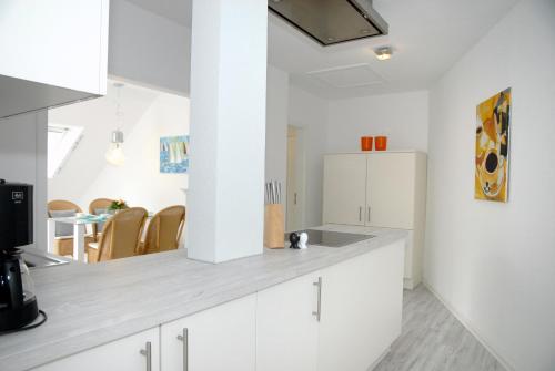 沙博伊茨Seeschwalbe的厨房配有白色橱柜和白色冰箱。