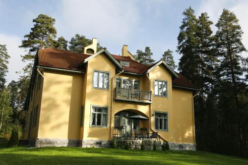 蓬卡哈尤Villa Urhola, Kruunupuisto的黄色房子的一侧设有阳台