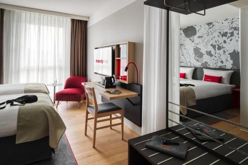 卡尔斯鲁厄IntercityHotel Karlsruhe的酒店客房配有一张床和一张带电脑的书桌