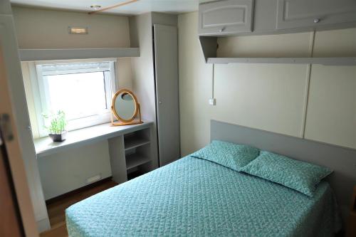 帕塔亚什AquaHause的一间卧室配有一张带蓝色棉被的床和窗户。