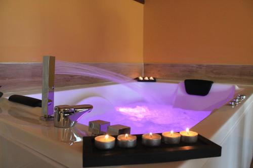 伊斯拉Villas, El Mirador de Isla的配有紫色照明和蜡烛的浴缸