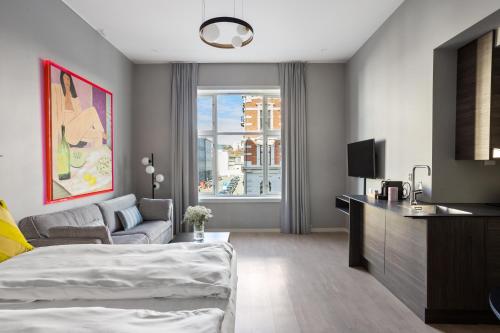 奥斯陆numa l Topp Apartments的一间卧室配有一张床、一台电视和一张沙发