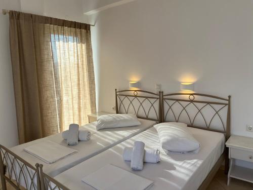 安迪帕罗斯岛Hotel Chrisoula的卧室配有一张带白色床单和毛巾的大床。
