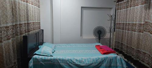 达卡Kompass Homestay - Affordable AC Room With Shared Bathroom in Naya Paltan Free WIFI的小房间设有一张床和一个风扇