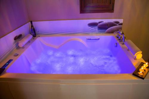 伊斯拉Villas Verdemar的紫色照明的客房内的按摩浴缸