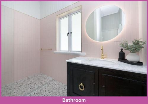汤斯维尔Harold Street 139的粉红色的浴室设有水槽和镜子