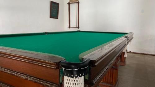 里约达欧特拉斯Pousada Puerta Del Sol Rio das Ostras的一张绿色的台球桌,坐在一个房间里